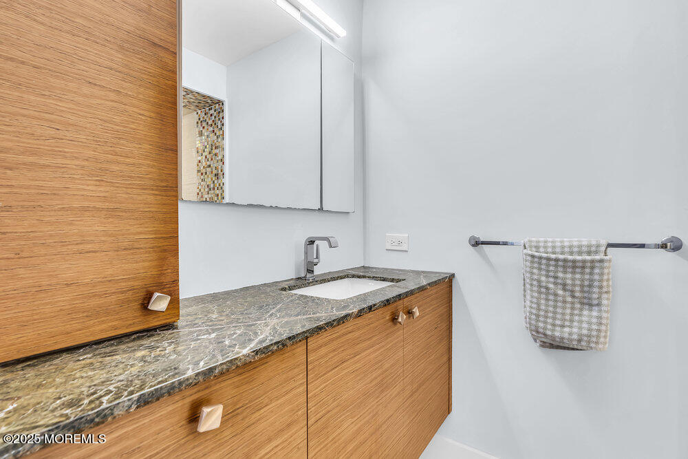 28 Riverside Avenue, Unit 2G Red Bank, NJ 07701 - Photo 17 of 34 a bathroom with a granite countertop sink and a mirror