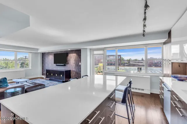 a living room with furniture a flat screen tv and a large window