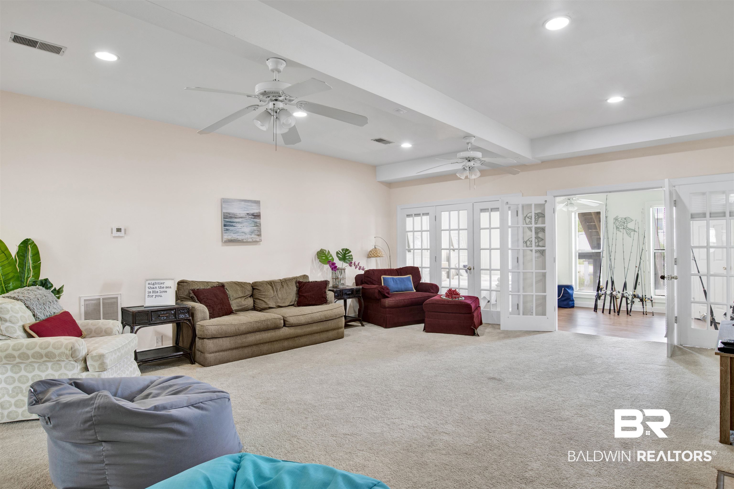 33093 River Road Orange Beach, AL 36561 - Photo 20 of 30 Carpeted living room with beamed ceiling, french doors, and ceiling fan