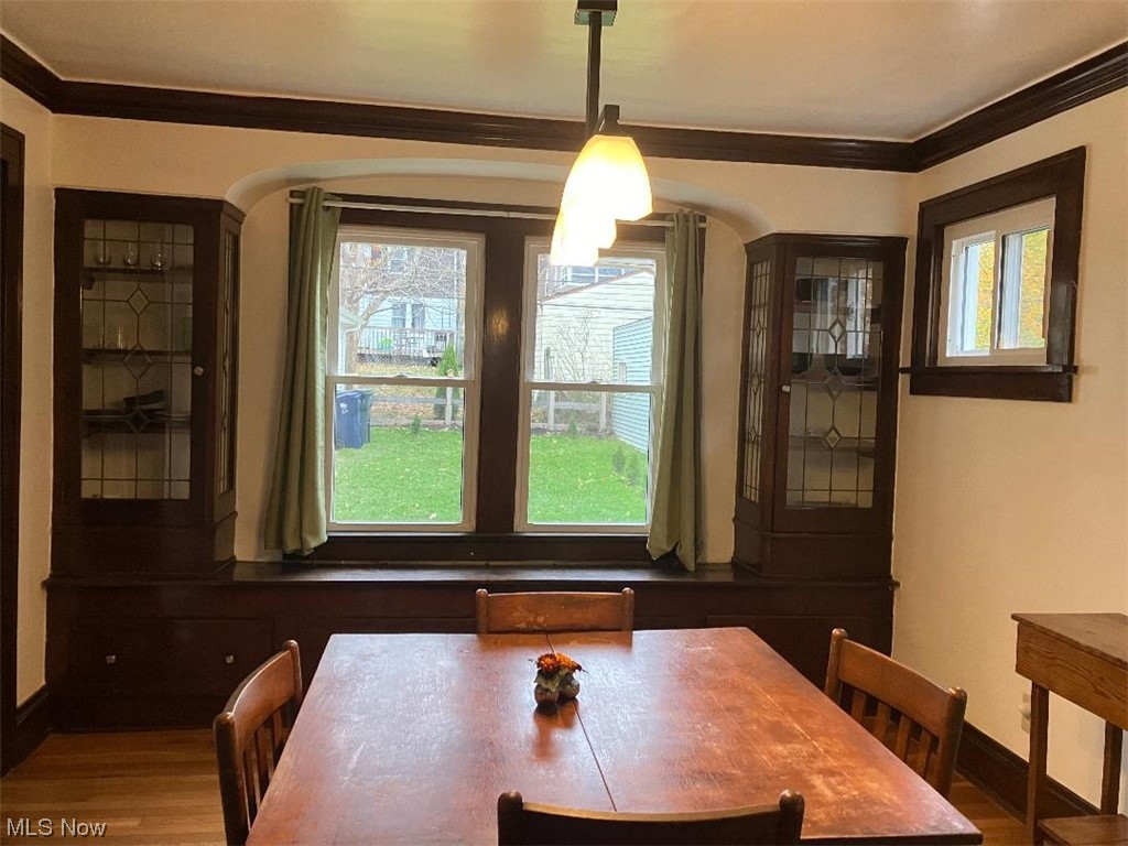 3808 Delmore Road Cleveland, OH 44121 - Photo 5 of 27 Dining room featuring a healthy amount of sunlight, ornamental molding, and hardwood / wood-style floors