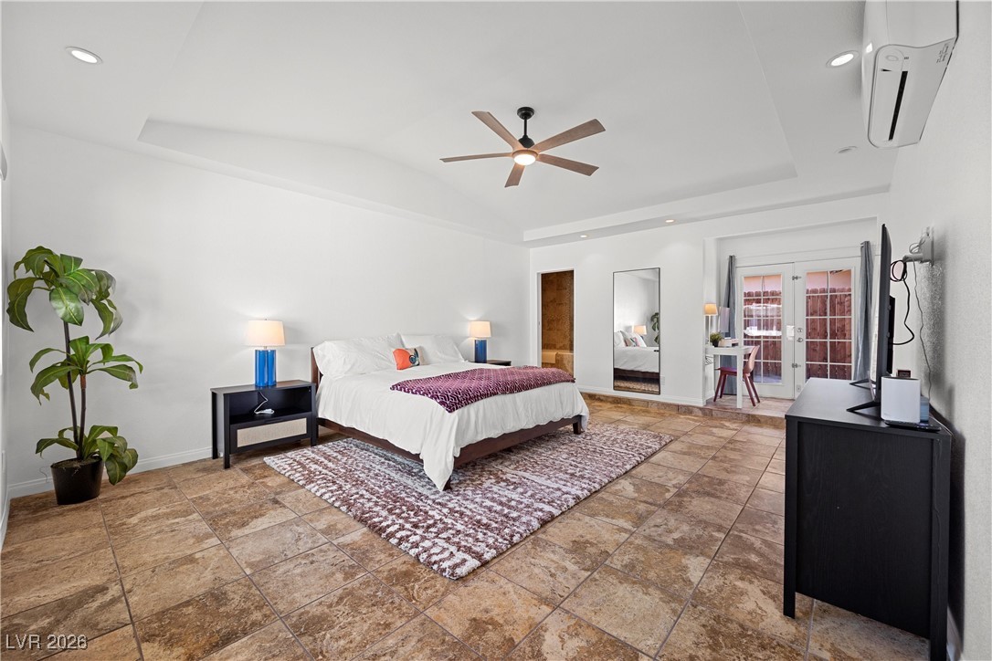 1554 Raindance Way Las Vegas, NV 89169 - Photo 8 of 25 Bedroom featuring french doors, a raised ceiling, an AC wall unit, vaulted ceiling, and baseboards
