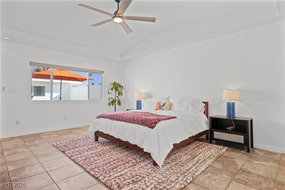 1554 Raindance Way Las Vegas, NV 89169 - Photo 9 of 25 Bedroom featuring baseboards, vaulted ceiling, and a ceiling fan