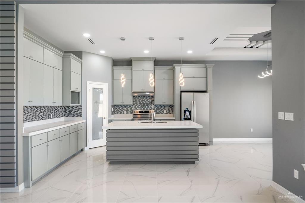 1402 Tee Box Drive Weslaco, TX 78596 - Photo 6 of 20 a view of kitchen with sink stainless steel appliances and cabinets