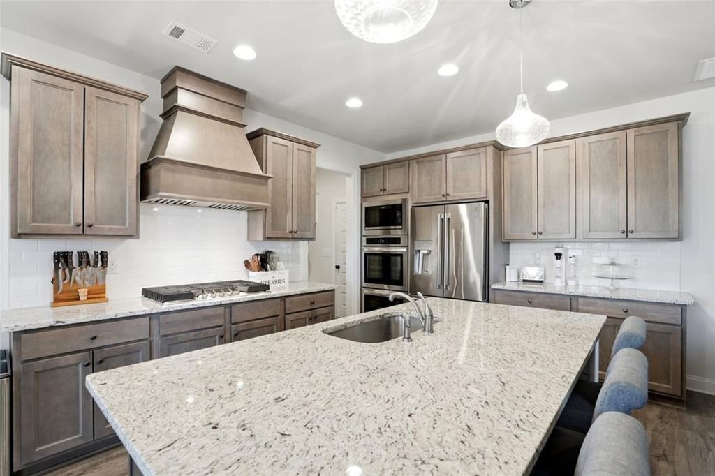 449 Banff Drive Winder, GA 30680 - Photo 11 of 56 a kitchen with stainless steel appliances granite countertop a sink refrigerator and cabinets