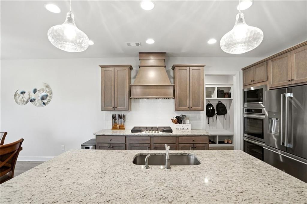 449 Banff Drive Winder, GA 30680 - Photo 12 of 56 a kitchen with stainless steel appliances granite countertop a sink refrigerator stove and microwave