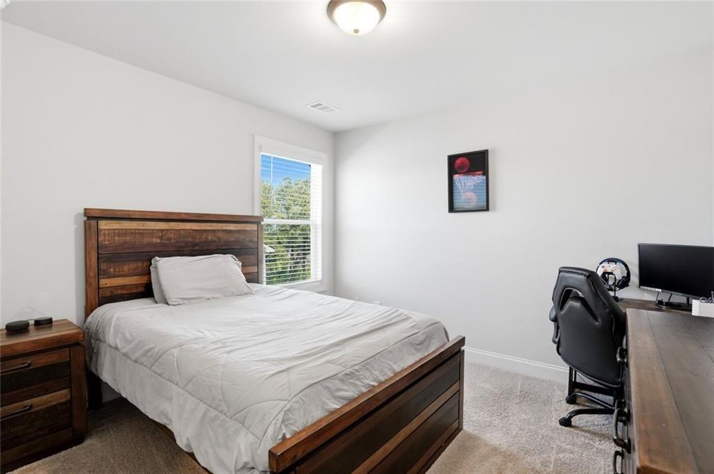 449 Banff Drive Winder, GA 30680 - Photo 29 of 56 a bedroom with a bed and a desk