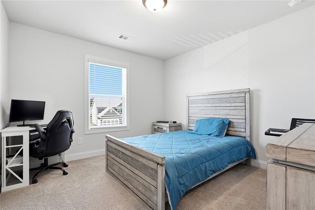 449 Banff Drive Winder, GA 30680 - Photo 30 of 56 a bedroom with a bed and a desk