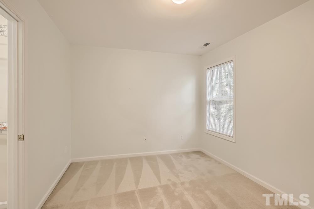 303 Whitney Lane Durham, NC 27713 - Photo 19 of 28 an empty room with a white cabinet and a window