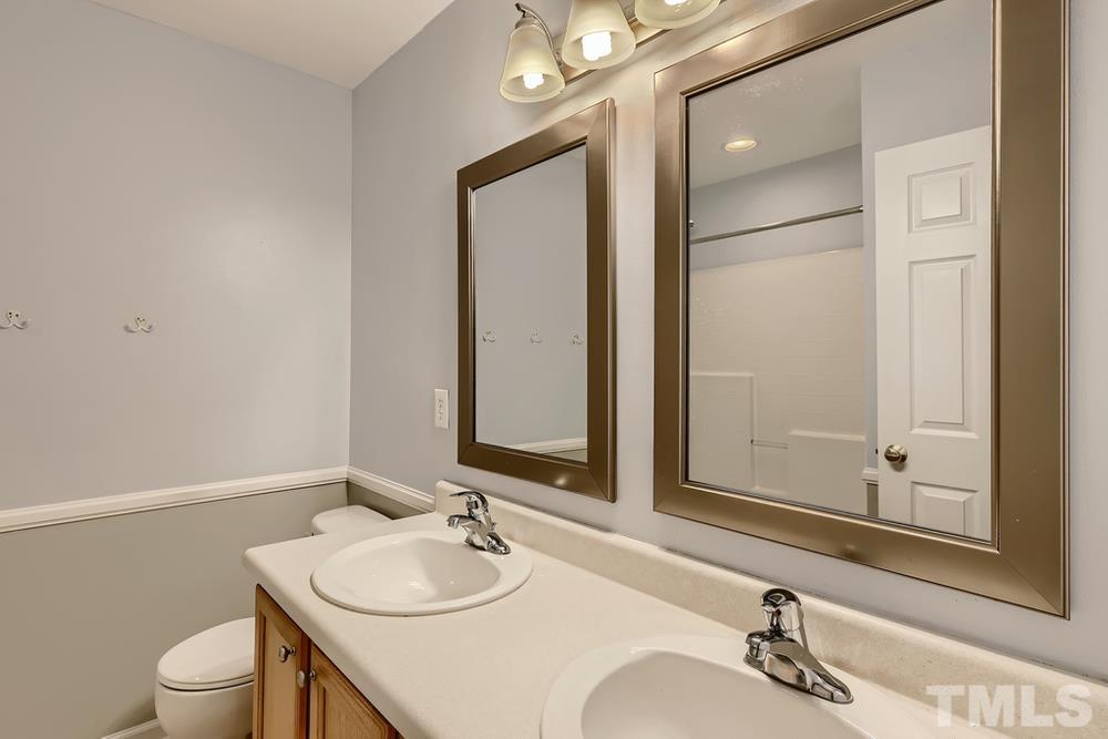 303 Whitney Lane Durham, NC 27713 - Photo 20 of 28 a bathroom with a sink vanity granite and a mirror