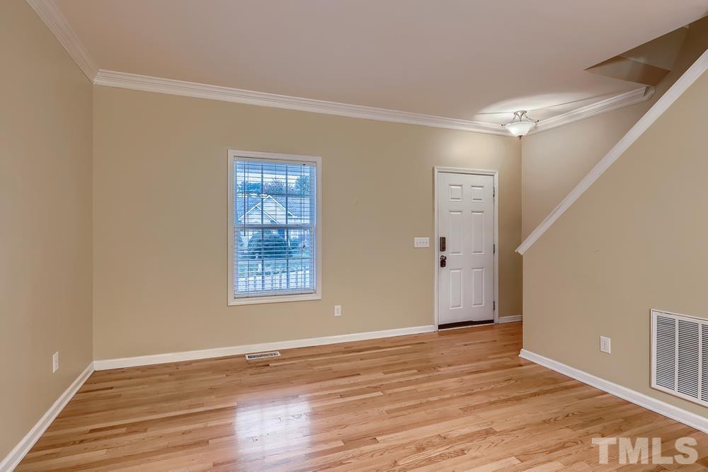303 Whitney Lane Durham, NC 27713 - Photo 3 of 28 a view of an empty room with wooden floor and a window