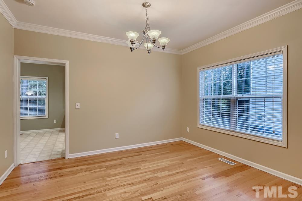 303 Whitney Lane Durham, NC 27713 - Photo 5 of 28 a view of an empty room with wooden floor and a window