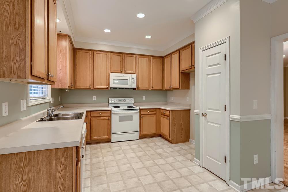 303 Whitney Lane Durham, NC 27713 - Photo 8 of 28 a kitchen with a refrigerator sink and cabinets