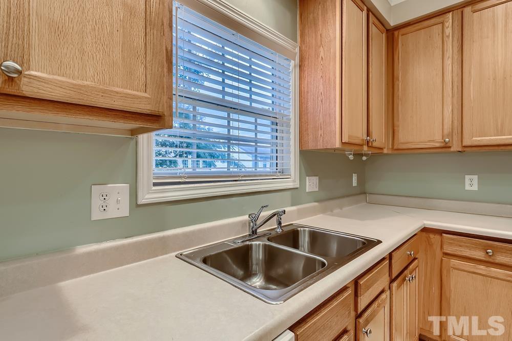 303 Whitney Lane Durham, NC 27713 - Photo 9 of 28 a kitchen with a sink cabinets and a window