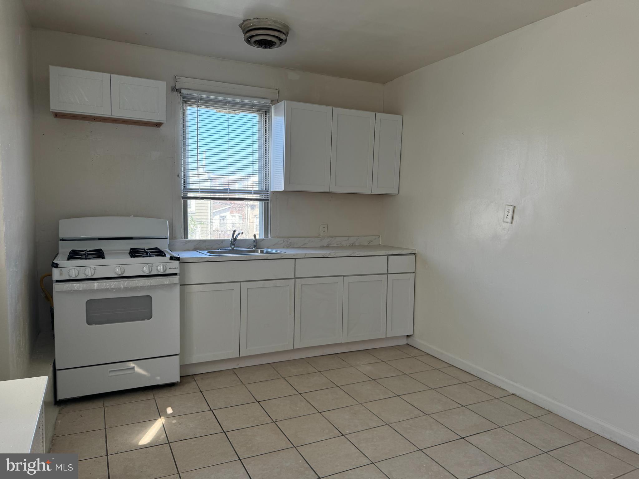 2115 Stenton Avenue Philadelphia, PA 19138 - Photo 8 of 11 a kitchen with a stove sink and cabinets