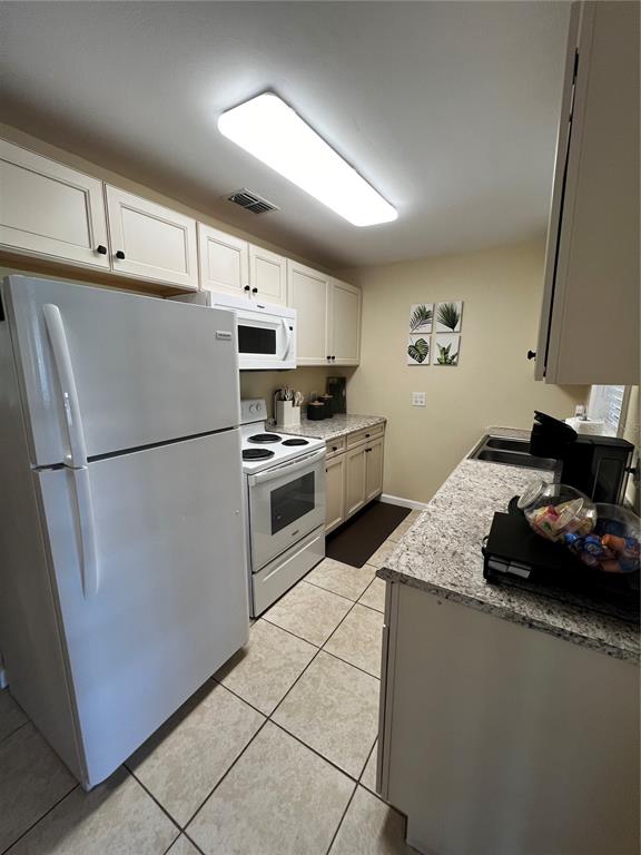 138 Woods Road San Mateo, FL 32187 - Photo 7 of 9 a kitchen with granite countertop a refrigerator and a sink
