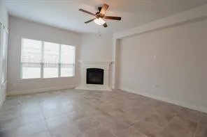 an empty room with windows and fireplace