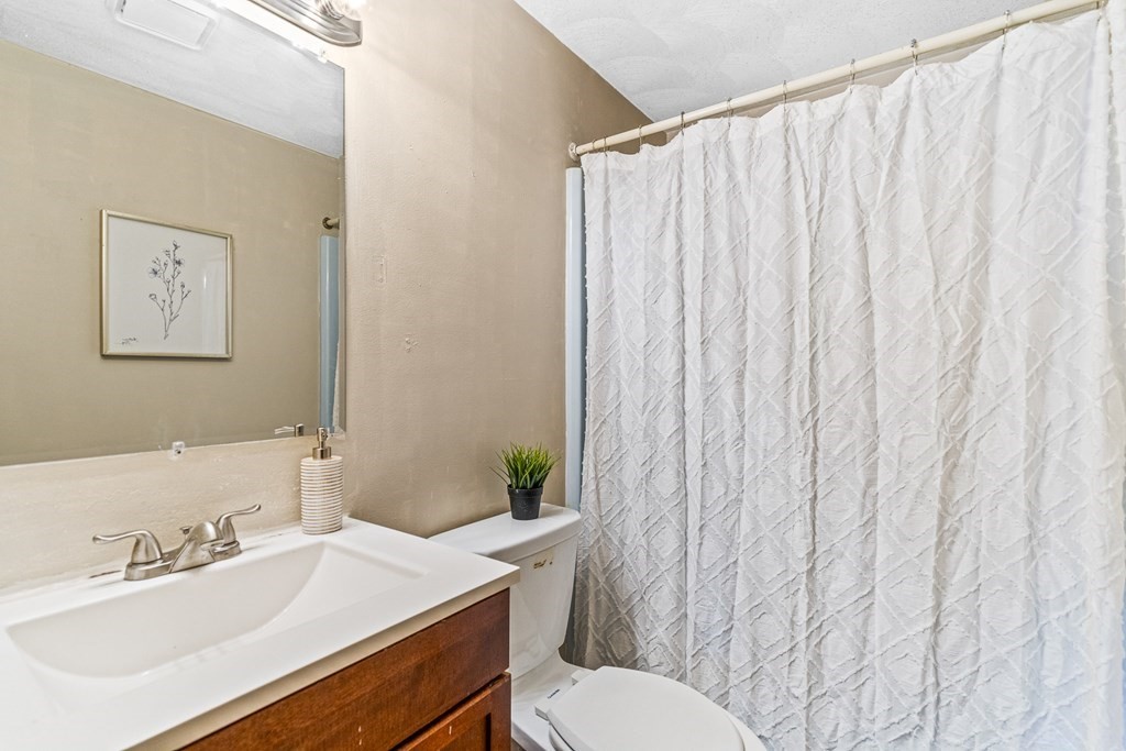 23 Heard Street, Unit 23 Chelsea, MA 02150 - Photo 18 of 27 a bathroom with a sink vanity mirror and toilet