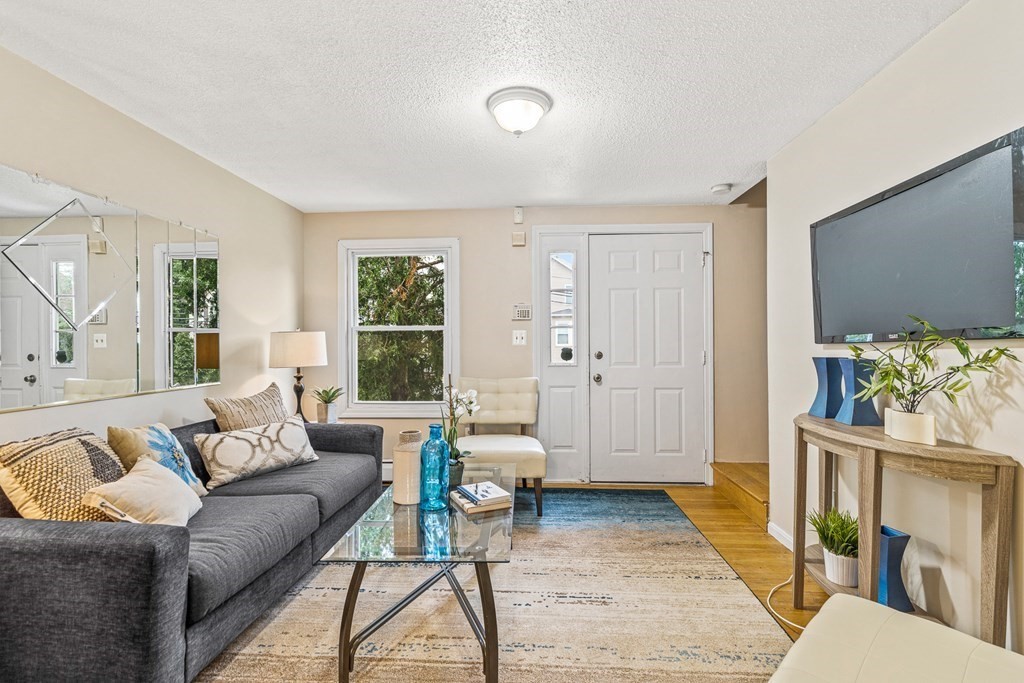 23 Heard Street, Unit 23 Chelsea, MA 02150 - Photo 4 of 27 a living room with furniture and a large window