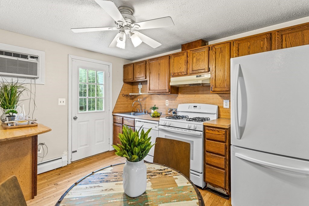 23 Heard Street, Unit 23 Chelsea, MA 02150 - Photo 8 of 27 a kitchen with stainless steel appliances granite countertop a refrigerator a stove a sink dishwasher and white cabinets with wooden floor