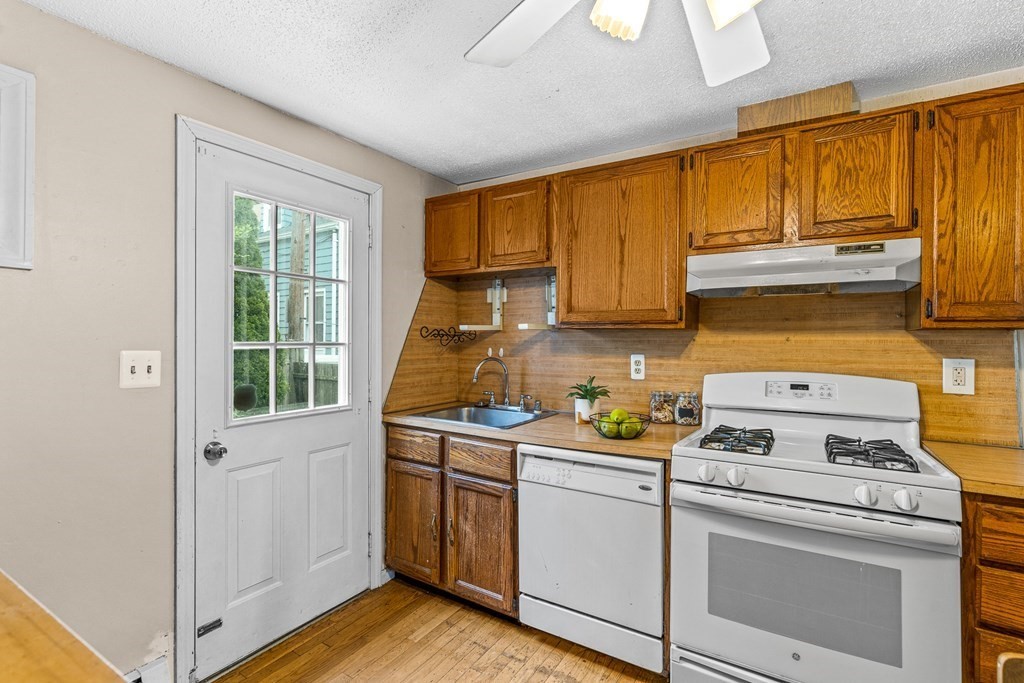 23 Heard Street, Unit 23 Chelsea, MA 02150 - Photo 9 of 27 a kitchen with a stove a sink and cabinets