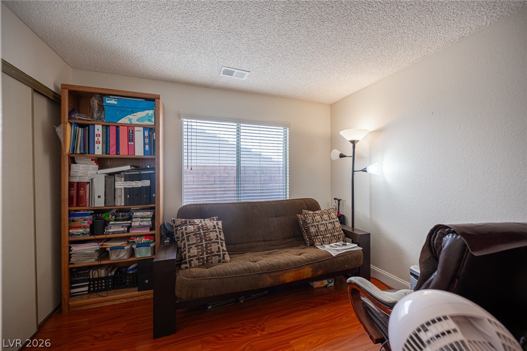718 Rusty Spur Drive Henderson, NV 89014 - Photo 29 of 50 Rich hardwood flooring enhances this adaptable living space, ideal for a comfortable home office or extra guest room.