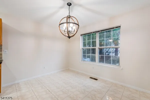 a view of wooden floor and a chandelier in a room