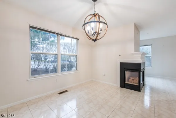 a view of an empty room with a window and kitchen view