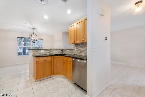 a kitchen with stainless steel appliances granite countertop a sink and a refrigerator
