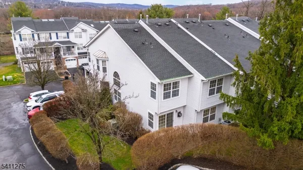 an aerial view of a house with a yard and large tree