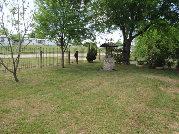 a view of a yard with large trees