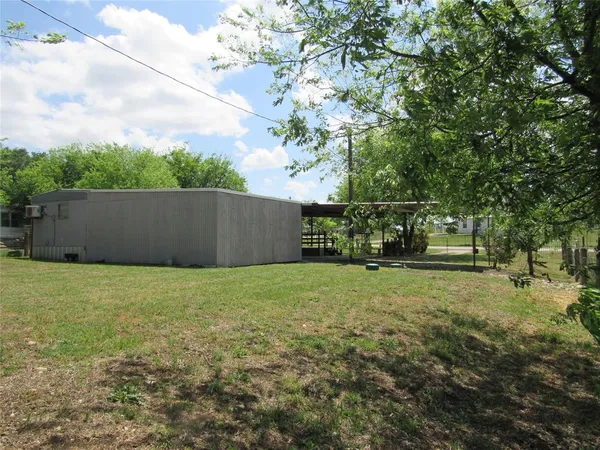 a backyard of a house with lots of plants and trees