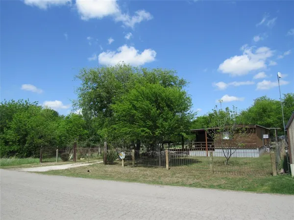 a backyard of a house with lots of green space and trampoline