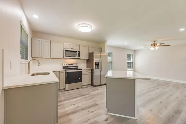 a kitchen with kitchen island a sink stainless steel appliances and cabinets