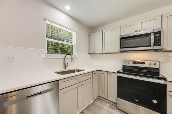 a kitchen with a sink stove and microwave
