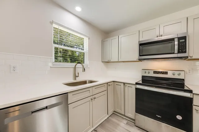 a kitchen with a sink stove and microwave