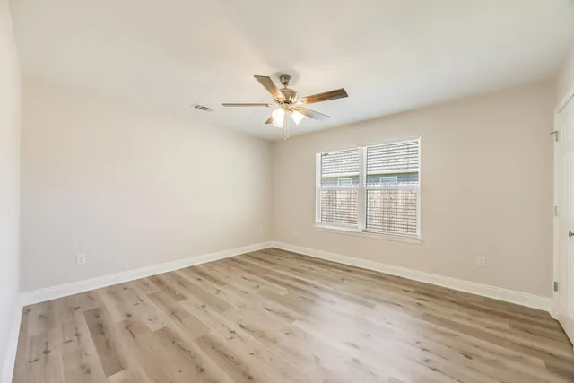 wooden floor in an empty room with a window
