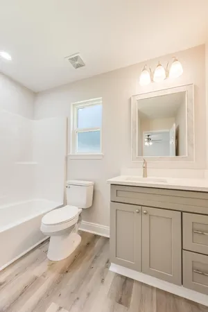 a bathroom with a sink a toilet and a mirror