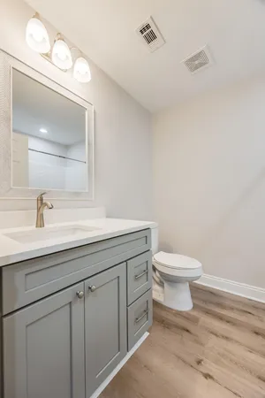 a bathroom with a toilet a sink and mirror