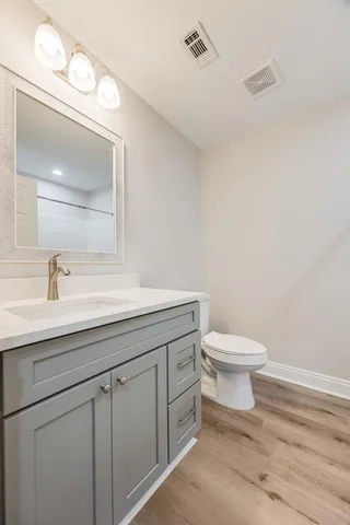 a bathroom with a toilet a sink and mirror