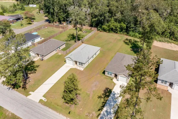 an aerial view of residential houses with yard