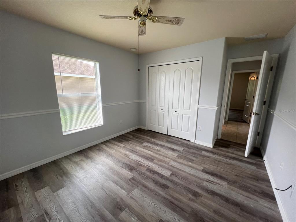 99 Flanders Street Port Charlotte, FL 33954 - Photo 14 of 29 an empty room with wooden floor and windows