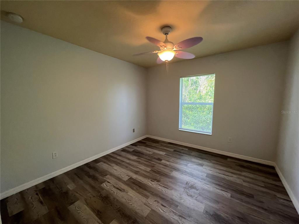 99 Flanders Street Port Charlotte, FL 33954 - Photo 16 of 29 a view of an empty room with window and wooden floor