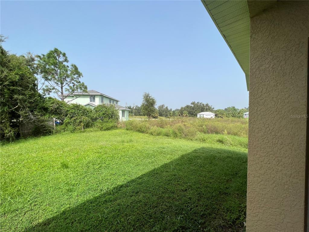 99 Flanders Street Port Charlotte, FL 33954 - Photo 28 of 29 a view of a green field with an outdoor space