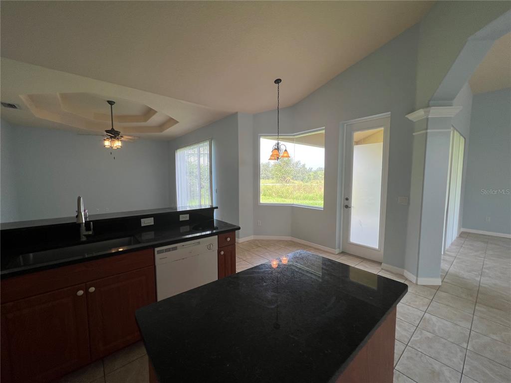 99 Flanders Street Port Charlotte, FL 33954 - Photo 9 of 29 a kitchen with granite countertop a sink and a stove top oven