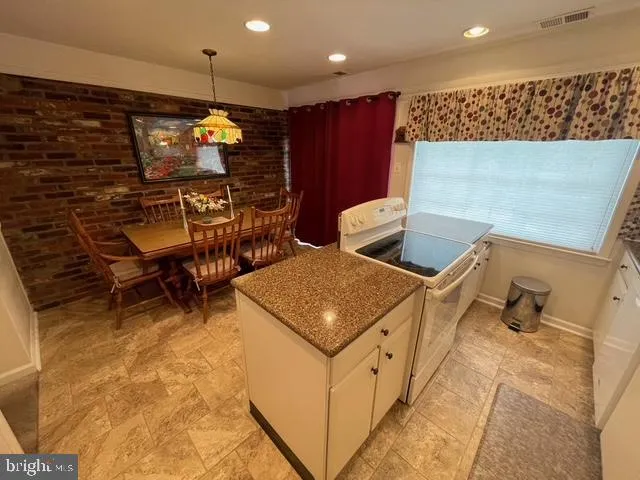 a kitchen with stainless steel appliances granite countertop a sink and a refrigerator