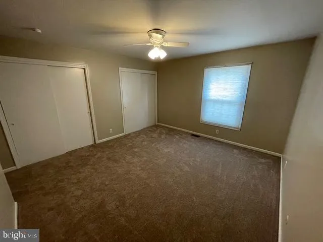 a view of an empty room with a chandelier fan