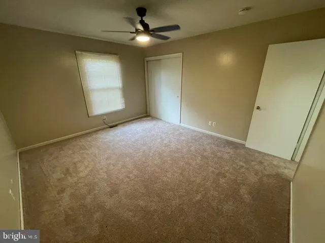 a view of a big room with windows and chandelier fan