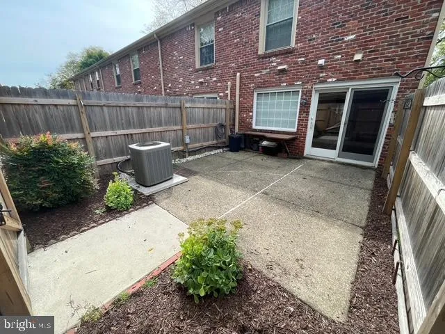 a view of a backyard with a chair and potted plants