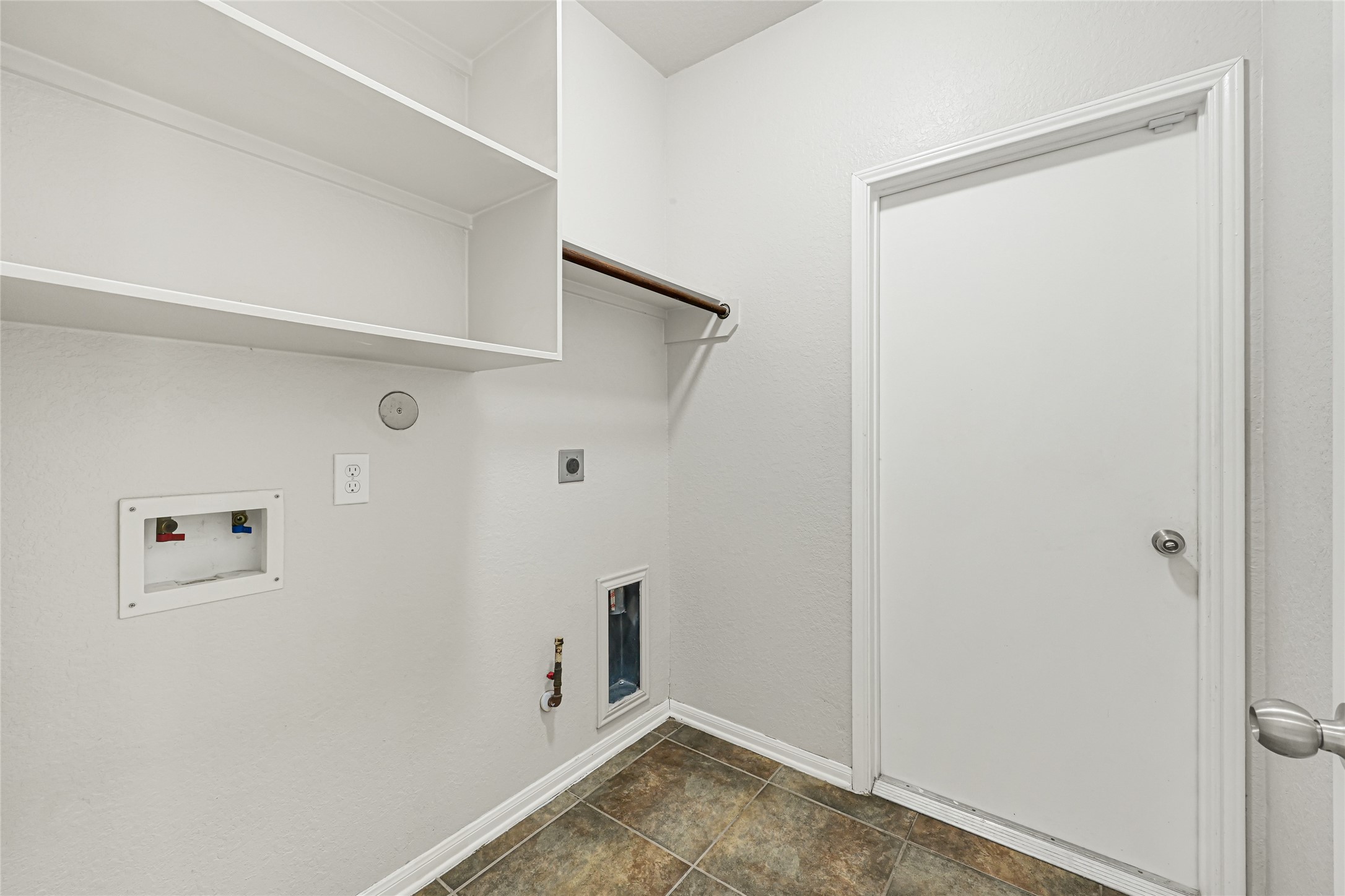4702 Sedgewood Drive Rosenberg, TX 77471 - Photo 13 of 24 This house has a laundry room with tiled flooring, a built-in shelf, and space for a washer and dryer with a door that leads to garage.