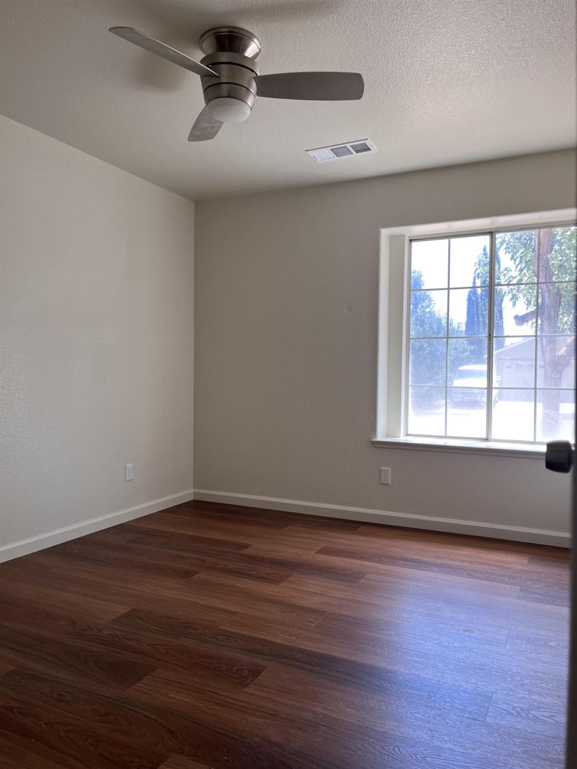 605 El Monte Street Madera, CA 93637 - Photo 11 of 17 a view of an empty room with wooden floor and a window